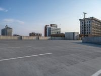 several large empty parking spaces in the city with buildings nearby in front of them -