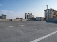 several large empty parking spaces in the city with buildings nearby in front of them -