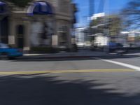 people are walking down the road near a store with blue and white awnings