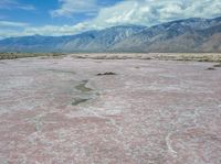 a vast area with mountains in the distance and water on it's sides, as if painted by salt and mud