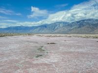 a vast area with mountains in the distance and water on it's sides, as if painted by salt and mud