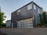 a big garage building that has a large window on it that is located off of the driveway