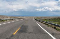 an empty street leading over a long, stretch of highway with mountains in the distance