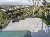 this home in beverly hills has an outdoor fireplace and hot tub overlooking the city on the other side