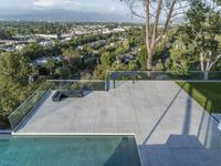 this home in beverly hills has an outdoor fireplace and hot tub overlooking the city on the other side