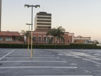 a large parking lot with a light pole on top of it and palm trees behind it