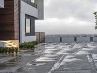 the front patio is in the rain with a bench and umbrellas in the rain