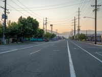 an empty street in front of a large red brick building on the other side of the road is a street light that has a line for motorists