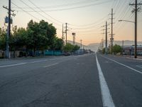 an empty street in front of a large red brick building on the other side of the road is a street light that has a line for motorists