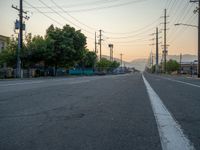 an empty street in front of a large red brick building on the other side of the road is a street light that has a line for motorists