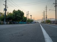 an empty street in front of a large red brick building on the other side of the road is a street light that has a line for motorists