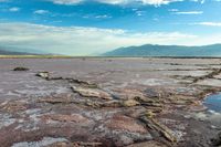 a large open area of desert with some water and rock formations that are exposed from mud