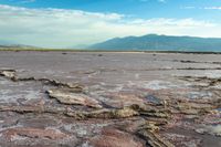 a large open area of desert with some water and rock formations that are exposed from mud