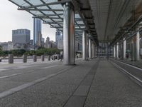 a large walkway going up to the ground of a skyscraper area in a city with buildings and cars