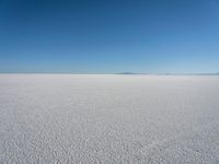 the view from the top of a salt flat in a deserted area with an distant mountain range in the distance