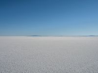 the view from the top of a salt flat in a deserted area with an distant mountain range in the distance