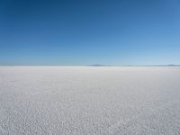 the view from the top of a salt flat in a deserted area with an distant mountain range in the distance