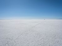 the view from the top of a salt flat in a deserted area with an distant mountain range in the distance