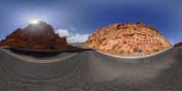 a view of a road through a 3d glass fish eye lens of the desert mountains