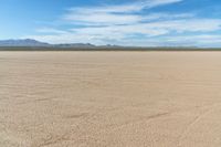 a motorcycle in the middle of an empty plain plain with lots of dirt and mountains