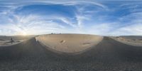 a panoramic view of the desert with some clouds in the background and some small animal figures