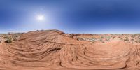 a very pretty desert with a sun in the background and small rock formations near by