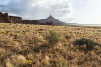 a very large desert plain with rocks and grass around it and the sun coming through