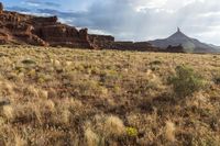 a very large desert plain with rocks and grass around it and the sun coming through