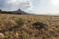 a very large desert plain with rocks and grass around it and the sun coming through