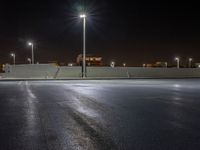 the empty parking lot at night, ready to be lit up by floodlights and street lamps