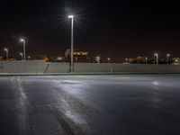 the empty parking lot at night, ready to be lit up by floodlights and street lamps