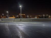 the empty parking lot at night, ready to be lit up by floodlights and street lamps