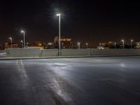 the empty parking lot at night, ready to be lit up by floodlights and street lamps