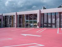 the building with white lines all over it in pink paint with a car parked in front