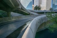 some large concrete bridges next to a body of water in the middle of a city