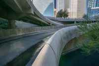 some large concrete bridges next to a body of water in the middle of a city