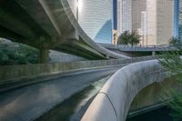 some large concrete bridges next to a body of water in the middle of a city