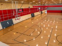 an empty gym is seen in this image, the floor has been cleaned and the flooring is red