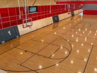 an empty gym is seen in this image, the floor has been cleaned and the flooring is red