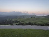 there is a car that is stopped on a hill and looks over at the mountain