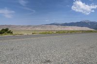 a lone motorcycle on a deserted open road with mountains in the background, at the bottom of the highway