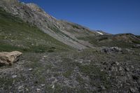 several rocks and flowers in the mountains with a sky background in the background, in the foreground, and a person on a rock trail