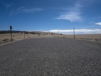 a paved beach with a fence in front of it and the ocean in the distance