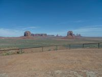 the view from a train traveling by the mountains of monument valley near a large gate that is open