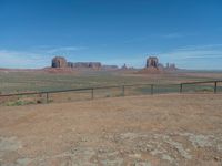 the view from a train traveling by the mountains of monument valley near a large gate that is open