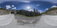 a fish eye lens shows the view of a winding road and the mountains in the distance