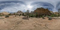 the image shows a panorama view looking up at a person walking in the mountains of zion