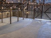 the inside of a barn, with lights on and there is also a wooden structure