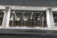 a hotel's entrance at night with lights in it and a sign out front