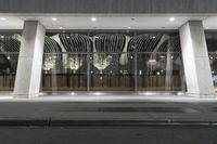 a hotel's entrance at night with lights in it and a sign out front